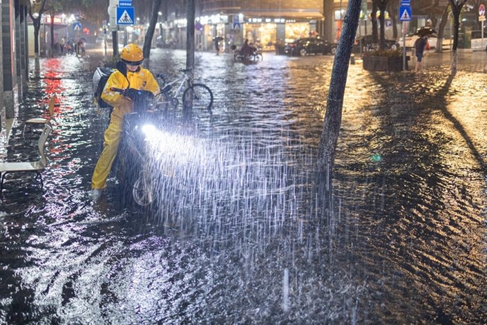 A Meituan driver makes a delivery during a downpour on May 20 in Guangzhou, South China’s Guangdong province.